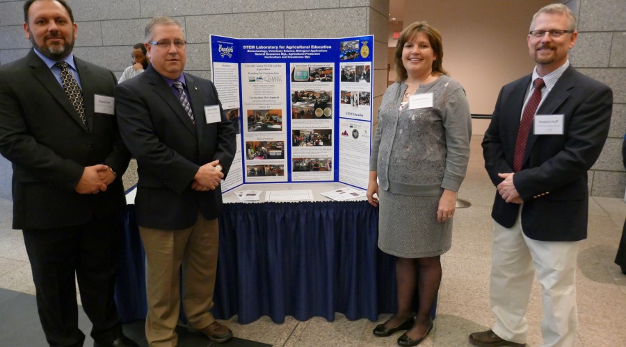 Two adults standing in front of a poster presentation. 